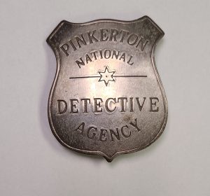 A close-up image of a Pinkerton National Detective Agency Badge found at the National Canal Museum support center. The badge shows signs of age, but is in good-condition.