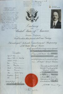 A large, folded parchment emergency passport issued to Archibald Johnston by the U.S. ambassador in London in 1914, showing visible creases from repeated folding.