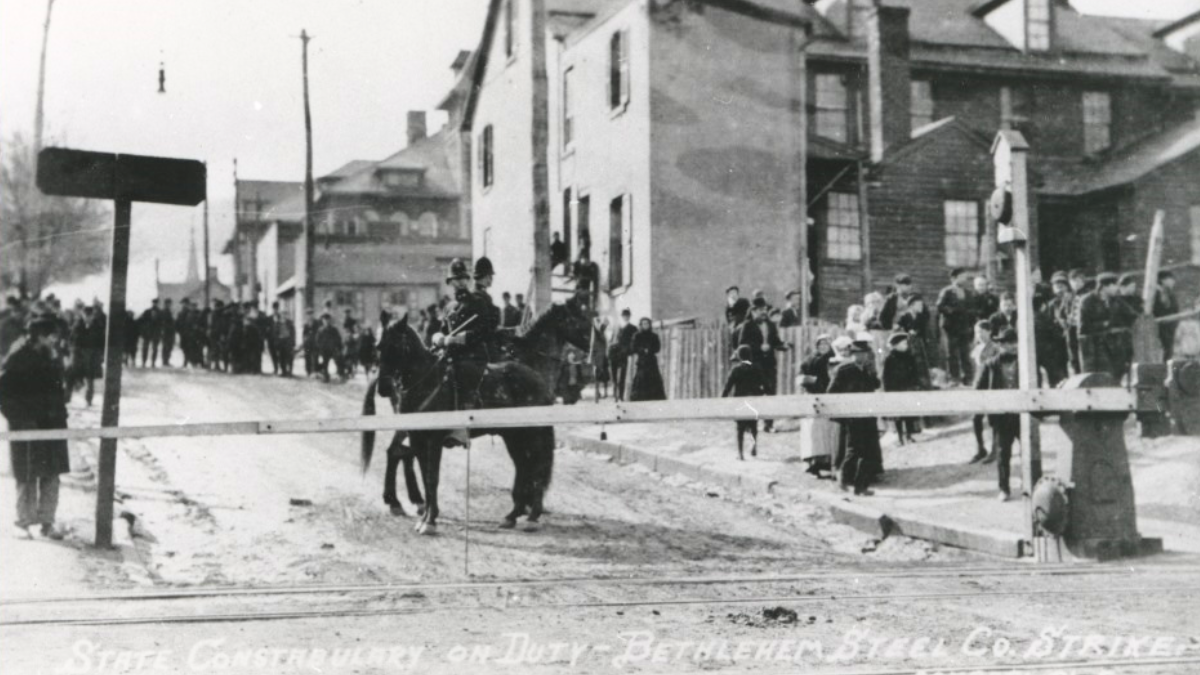 A historic photo in black and white, showing state police officers, some on hoseback patrolling Bethlehem, 1910.